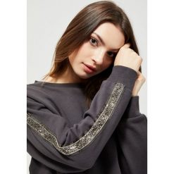 Bluza z ozdobnymi lampasami. Bluzy damskie Moodo, xl, bez wzorów, z bawełny, bez rękawów, bez kaptura. Za 79,99 zł.