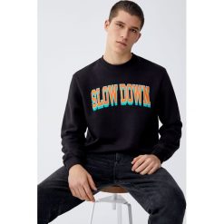 Czarna bluza z napisem „Slow Down”. Czarne bluzy męskie Pull&Bear, m, z napisami, bez kołnierzyka, bez rękawów, bez kaptura. Za 79,90 zł.