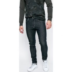 Wrangler - Jeansy Strangler Rinse. Niebieskie jeansy męskie skinny Wrangler, z aplikacjami, z bawełny. W wyprzedaży za 219,90 zł.