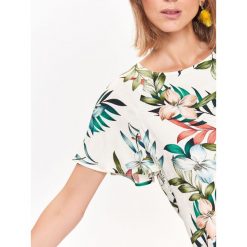 Bluzka w kwiatowy wzór, z odkrytymi plecami. Białe bluzki damskie Top Secret, w kwiaty, z jeansu, eleganckie, z dekoltem na plecach, bez rękawów. W wyprzedaży za 39,99 zł.
