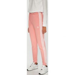 Adidas Originals - Spodnie. Różowe spodnie damskie adidas Originals, bez wzorów, z bawełny, casualowe. W wyprzedaży za 199,90 zł.