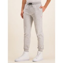 Spodnie dresowe Guess U01Q01 FL038. Szare jeansy męskie Guess, xxl, z aplikacjami, z bawełny. W wyprzedaży za 269,00 zł.