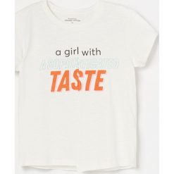Bawełniany t-shirt z asymetryczny przeszyciem - Kremowy. Białe t-shirty damskie Reserved, bez wzorów, z bawełny, z asymetrycznym kołnierzem. W wyprzedaży za 9,99 zł.