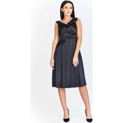 Elegancka sukienka z ozdobą przy dekolcie czarny. Czarne sukienki damskie N/A, na imprezę, z aplikacjami, eleganckie, bez kołnierzyka, bez rękawów. Za 164,12 zł.
