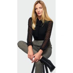 Czarna bluzka z wiązaniem. Czarne bluzki damskie Greenpoint, bez wzorów, z poliesteru, bez kołnierzyka, bez rękawów. Za 99,99 zł.
