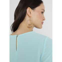 Vince Camuto TIERED TIE CUFF TEXTURED BLOUSE Bluzka aqua glow. Niebieskie bluzki damskie marki Vince Camuto, l, bez wzorów, z elastanu, bez kołnierzyka, bez rękawów. Za 379,00 zł.