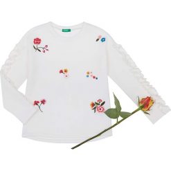 Bluza w kolorze białym ze wzorem. Białe bluzy niemowlęce Benetton Kids, z haftami, z bawełny, bez rękawów, bez kaptura. W wyprzedaży za 42,95 zł.