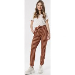 Jasnobrązowe Spodnie Oaralin. Pomarańczowe jeansy damskie Born2be, xl, z podwyższonym stanem. Za 59,99 zł.