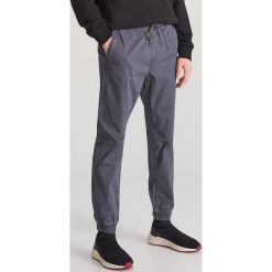 Bawełniane spodnie jogger - Szary. Szare spodnie męskie Reserved, m, bez wzorów, z bawełny. Za 129,99 zł.