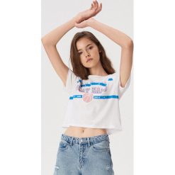 Koszulka ze sportowym nadrukiem - Biały. Białe t-shirty damskie Sinsay, s, z nadrukiem, bez kołnierzyka, bez rękawów, bez kaptura. W wyprzedaży za 14,99 zł.