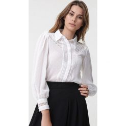 Biała Koszula Merigold. Białe bluzki damskie Born2be, do pracy, s, w koronkowe wzory, z tkaniny, biznesowe, bez kołnierzyka, bez rękawów. Za 99,99 zł.