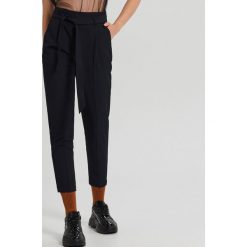 Spodnie paperbag z paskiem - Granatowy. Niebieskie spodnie damskie Cropp. Za 99,99 zł.