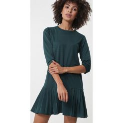 Ciemnozielona Sukienka Balwyn. Zielone sukienki damskie Born2be, xl, bez wzorów, z okrągłym kołnierzem, bez rękawów, mini, rozkloszowane. Za 79,99 zł.