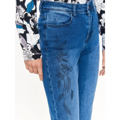 SPODNIE JEANSOWE Z NADRUKIEM. Niebieskie spodnie damskie Top Secret, z jeansu. W wyprzedaży za 59,99 zł.