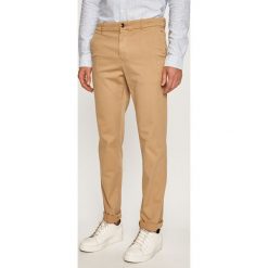 Calvin Klein - Spodnie. Brązowe spodnie męskie Calvin Klein, bez wzorów, z elastanu. W wyprzedaży za 299,90 zł.