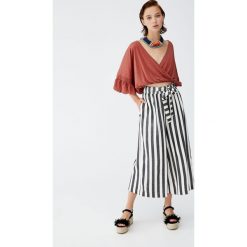 Spodnie culotte w paski z wiązaniem. Pomarańczowe spodnie damskie Pull&Bear. Za 79,90 zł.