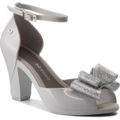 Sandały ZAXY - Diva Bow Sandal Fem 82442 Szary/Srebrny 50802 AA285083 02064. Szare klapki damskie Zaxy, z aplikacjami, z tworzywa sztucznego, bez obcasa, na obcasie. W wyprzedaży za 179,00 zł.