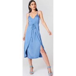 Linn Ahlborg x NA-KD Satynowa sukienka midi - Blue. Niebieskie sukienki na komunię marki Linn Ahlborg x NA-KD, z satyny, z kopertowym dekoltem, midi, kopertowe. W wyprzedaży za 40,19 zł.