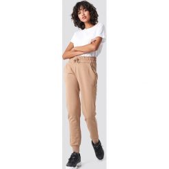 NA-KD Basic Spodnie dresowe basic - Beige. Brązowe spodnie damskie marki NA-KD Basic, z bawełny. Za 100,95 zł.