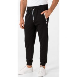 Guess Adam Spodnie dresowe Czarny. Czarne spodnie męskie Guess, xxl, z aplikacjami, z elastanu. Za 357,95 zł.