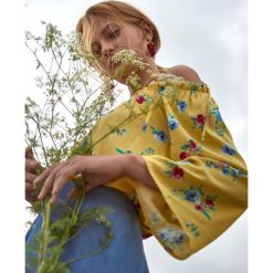 Bluzka damska z długim rękawem z wiązaniem na ramionach. Żółte bluzki damskie Top Secret, w kwiaty, z tkaniny, eleganckie, bez kołnierzyka, z długim rękawem. W wyprzedaży za 34,99 zł.