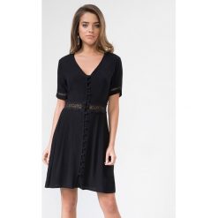 Sukienka w kolorze czarnym. Czarne sukienki damskie Urban Touch, bez wzorów, bez kołnierzyka, bez rękawów, mini, rozkloszowane. W wyprzedaży za 129,95 zł.