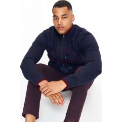 BLUZA ROZPINANA MĘSKA ZE STÓJKĄ I APLIKACJĄ. Czerwone bluzy męskie Top Secret, na zimę, m, z haftami, eleganckie, ze stójką, bez rękawów, bez kaptura. W wyprzedaży za 59,99 zł.
