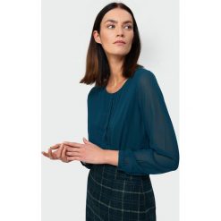 Elegancka bluzka z plisami. Bluzki damskie Greenpoint, bez wzorów, z poliesteru, eleganckie, bez kołnierzyka, bez rękawów. Za 49,99 zł.