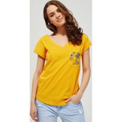 T-shirt z ozdobną kieszonką. Żółte bluzki damskie Moodo, xxl, w kwiaty, z bawełny, klasyczne, z dekoltem w serek, z krótkim rękawem. Za 29,99 zł.