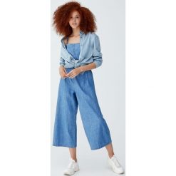 Kombinezon ze spodniami i guzikami z przodu. Niebieskie kombinezony damskie Pull&Bear, bez wzorów, bez kołnierzyka, bez rękawów. Za 139,00 zł.