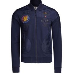 Bluza AERONAUTICA MILITARE Granatowy. Niebieskie bluzy męskie marki Aeronautica Militare, z haftami, z bawełny, militarne, ze stójką, bez rękawów, bez kaptura. W wyprzedaży za 812,00 zł.