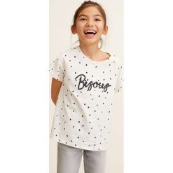 Mango Kids - Top dziecięcy Eme 110-164 cm. Białe bluzki dziewczęce Mango Kids, bez wzorów, z bawełny, z okrągłym kołnierzem, z krótkim rękawem, krótkie, bez kaptura. Za 49,90 zł.