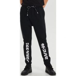 Dresowe joggery z napisami - Czarny. Czarne spodnie męskie Cropp, s, z napisami, z dresówki. Za 119,99 zł.