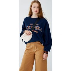 Bluza college z napisem. Szare bluzy damskie Pull&Bear, z napisami, bez rękawów, bez kaptura. Za 89,90 zł.