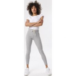Jasnoszare Legginsy Kallikea. Szare legginsy sportowe damskie Born2be, s, z aplikacjami, z dzianiny, z podwyższonym stanem, na fitness i siłownię. Za 39,99 zł.