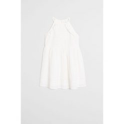 Mango Kids - Sukienka dziecięca Pals 110-140 cm. Białe sukienki dziewczęce Mango Kids, bez wzorów, z bawełny, bez rękawów, mini, rozkloszowane. Za 119,90 zł.