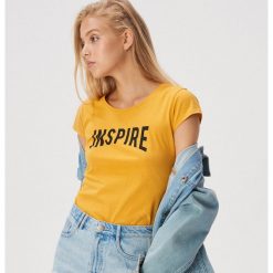 Koszulka z napisem Inspire - Żółty. Żółte koszulki damskie Sinsay, s, z napisami, bez kołnierzyka, bez rękawów. Za 9,99 zł.