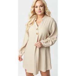 Jasnobeżowa Sukienka Adreathia. Brązowe sukienki damskie Born2be, xl, bez wzorów, ze stójką, z długim rękawem, długie, mini, trapezowe. Za 89,99 zł.