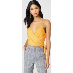 NA-KD Boho Kopertowy top na ramiączkach - Yellow. Żółte topy damskie NA-KD Boho, bez wzorów, bez kołnierzyka. W wyprzedaży za 36,58 zł.