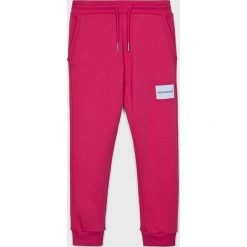 Calvin Klein Jeans - Spodnie dziecięce 116-164 cm. Różowe spodnie dziewczęce marki Calvin Klein Jeans, bez wzorów, z elastanu, casualowe. Za 269,90 zł.