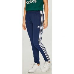 Adidas Originals - Spodnie. Niebieskie spodnie damskie adidas Originals, bez wzorów, z elastanu, casualowe. W wyprzedaży za 219,90 zł.