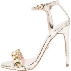 Carvela GAIL Sandały na obcasie gold. Żółte sandały damskie marki Carvela, ze skóry ekologicznej, na obcasie. W wyprzedaży za 551,20 zł.