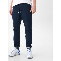 Joggery z kontrastowymi ściągaczami - Granatowy. Niebieskie spodnie męskie House, s, bez wzorów. W wyprzedaży za 49,99 zł.