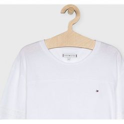 Tommy Hilfiger - Top dziecięcy 128-176 cm. Białe bluzki dziewczęce TOMMY HILFIGER, bez wzorów, z bawełny, z okrągłym kołnierzem, z krótkim rękawem, krótkie, bez kaptura. W wyprzedaży za 99,90 zł.