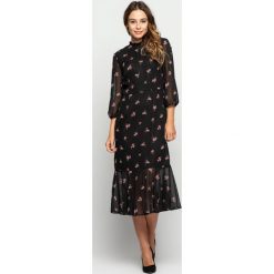 Czarna zwiewna sukienka w drobne kwiaty RABARBAR. Czarne sukienki damskie RABARBAR, na wesele, w kwiaty, bez kołnierzyka, bez rękawów. Za 349,00 zł.