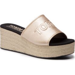 Klapki TOMMY JEANS - Shiny Metallic Flatform Mule EN0EN00546 Light Gold 715. Żółte klapki damskie marki Tommy Jeans, bez wzorów, z jeansu, bez obcasa, na obcasie. Za 359,00 zł.