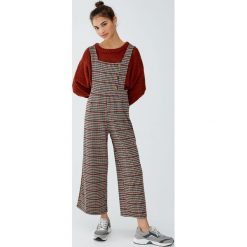 Kombinezon w kratkę na guziki. Kombinezony damskie Pull&Bear, w kratkę, bez kołnierzyka, bez rękawów. Za 109,00 zł.