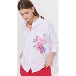 Koszula oversize w kwiaty - Biały. Białe koszule damskie Mohito, w kwiaty, bez kołnierzyka, bez rękawów. W wyprzedaży za 59,99 zł.