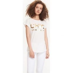T-SHIRT DAMSKI ZE ZŁOTYM NADRUKIEM. Białe t-shirty damskie TROLL, s, z nadrukiem, z bawełny, z okrągłym kołnierzem. W wyprzedaży za 14,99 zł.