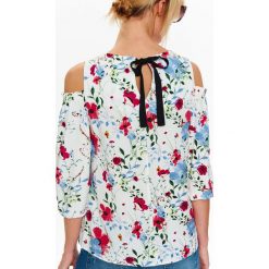 Bluzka w kwiaty cold shoulder z wiązaniem z tyłu. Białe bluzki damskie Top Secret, w kwiaty, z tkaniny, eleganckie, z dekoltem na plecach, bez rękawów. W wyprzedaży za 39,99 zł.